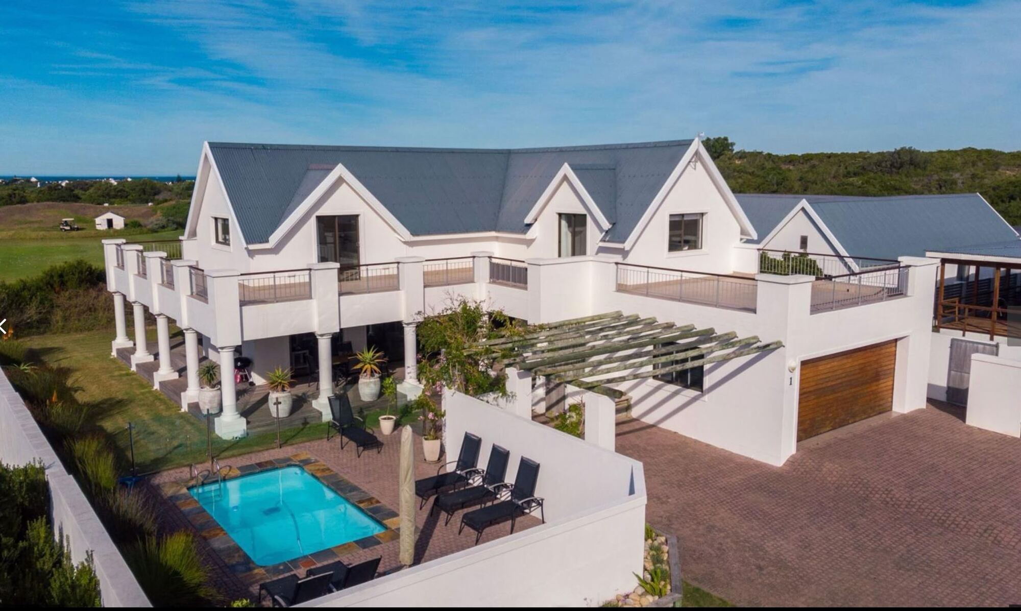 Aerial view of Wildehaven with its pool and courtyard, the St Francis Links fairway and the sea beyond